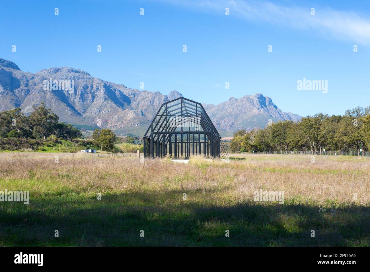 Glaskonservatorium, Gebäude, Gewächshaus, Treibhaus, Gewächshaus, das auf einem Feld auf einer Farm in Cape Winelands, Südafrika, leer ist Stockfoto
