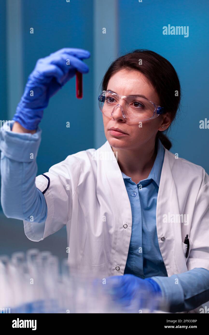 Biotechnologin Wissenschaftlerin, die mit einem Blutschlauch im Pharmalabor forscht. Forscher im Labor für chemische Medizin, der mit professionellen Technologiegeräten für die Entwicklung des Gesundheitswesens arbeitet. Stockfoto