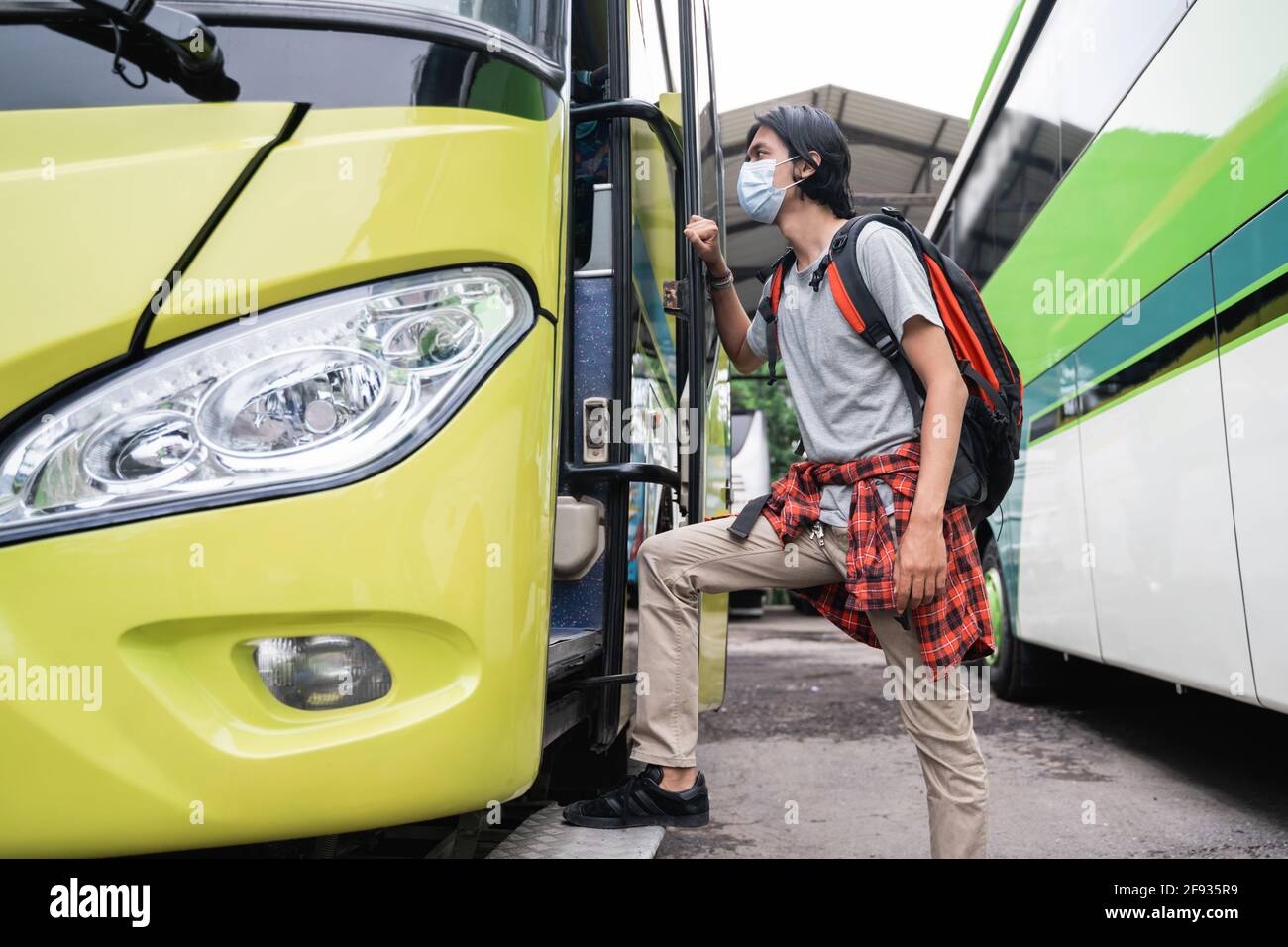 Ein Mann mit Gesichtsmasken fährt in den Bus. Stockfoto