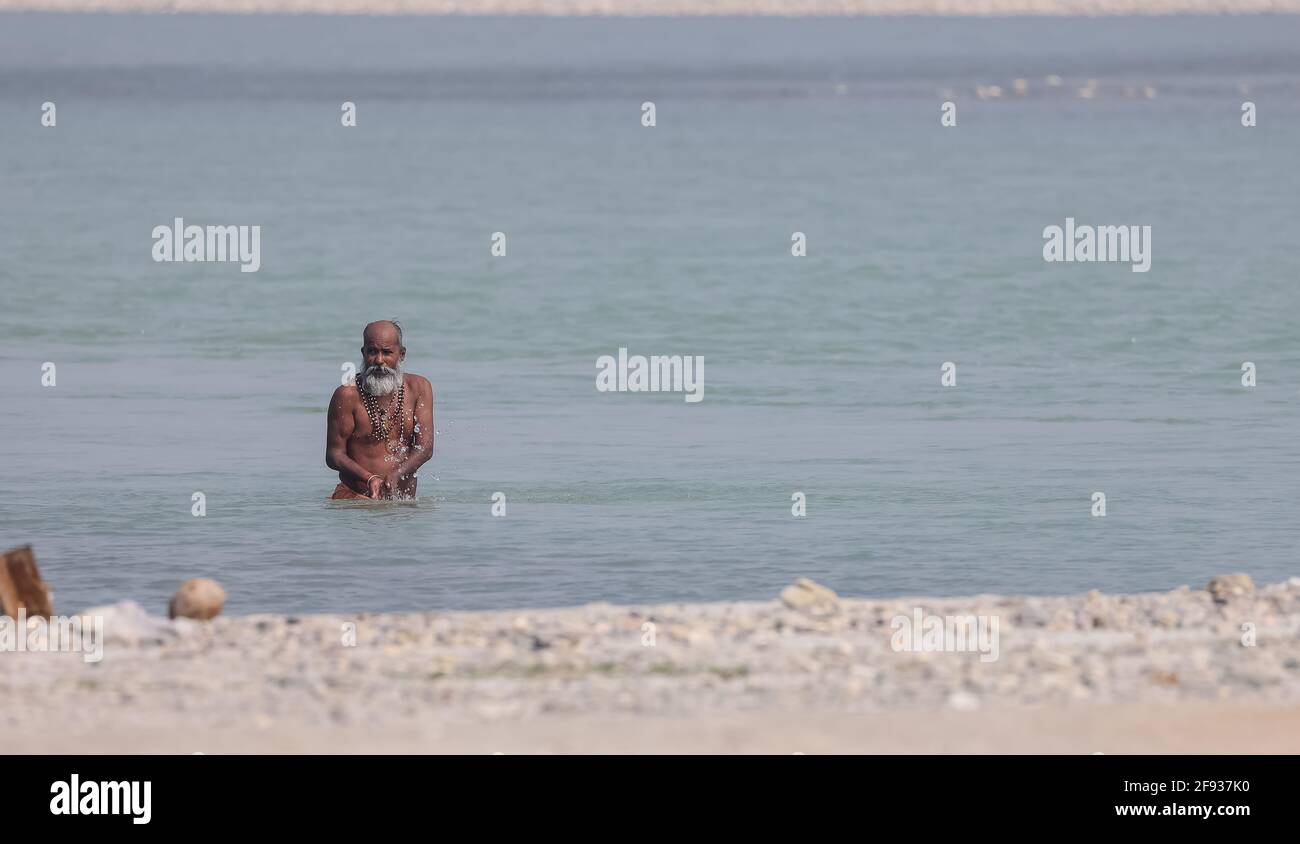 HARIDWAR, INDIEN, FEBRUAR 2021 : Portrait von indischem Sadhu, das heilige Dip nimmt, um Lord Sun in River Ganga bei Haridwar anzubeten. Stockfoto