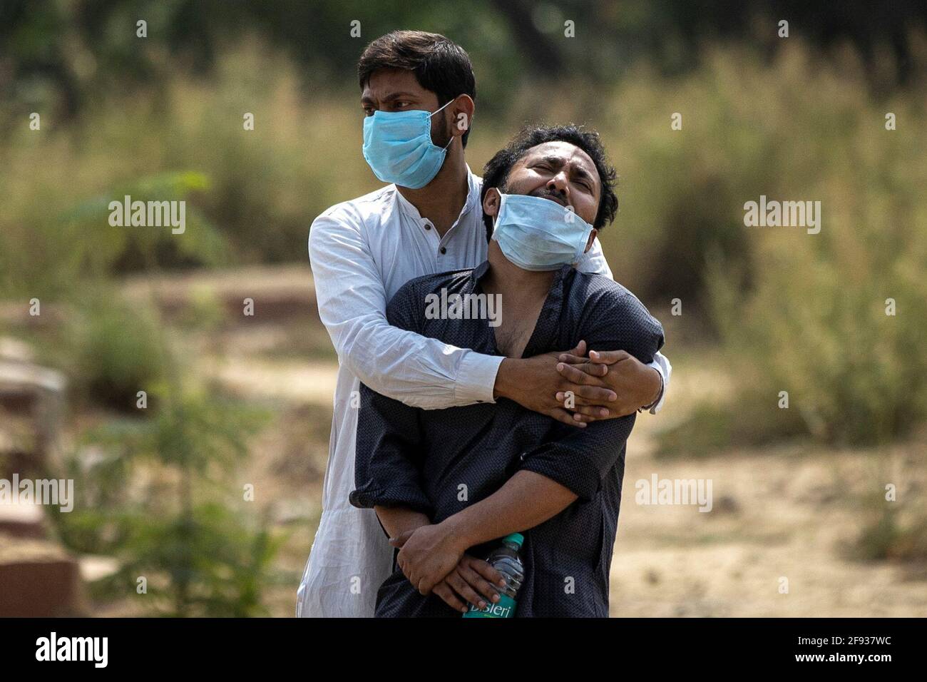 Ein Mann wird von seinem Verwandten getröstet, als er den Leichnam seines Vaters sieht, der an der Coronavirus-Krankheit (COVID-19) starb, bevor er am 16. April 2021 auf einem Friedhof in Neu-Delhi, Indien, begraben wurde. REUTERS/Danish Siddiqui Stockfoto