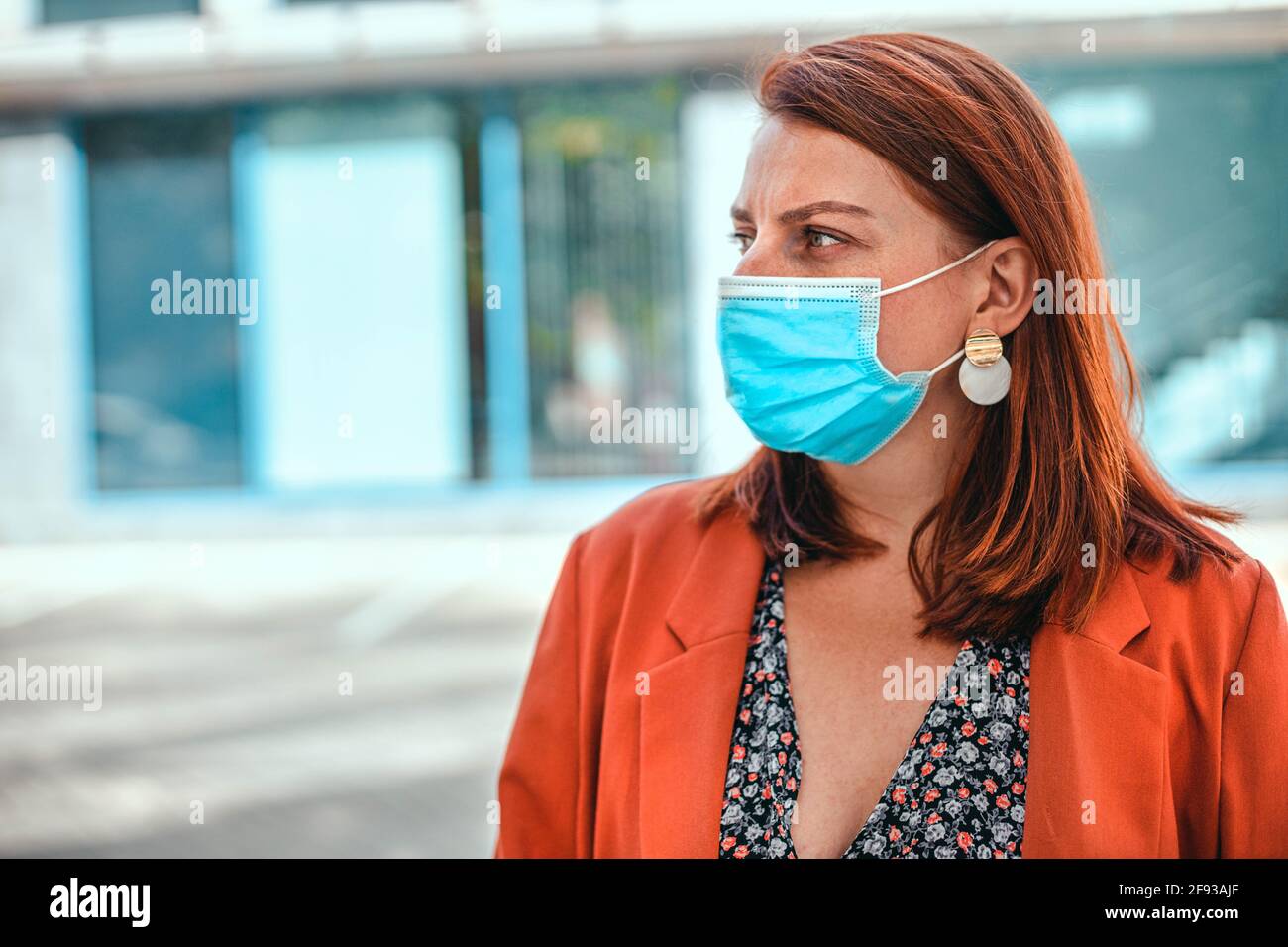 Junge Frau mit einem Füchshaar, das eine Gesichtsmaske gegen das Coronavirus MERS-Cov trägt, neuartiges Coronavirus 2019-nCoV. Konzept der Coronavirus-Quarantäne Stockfoto