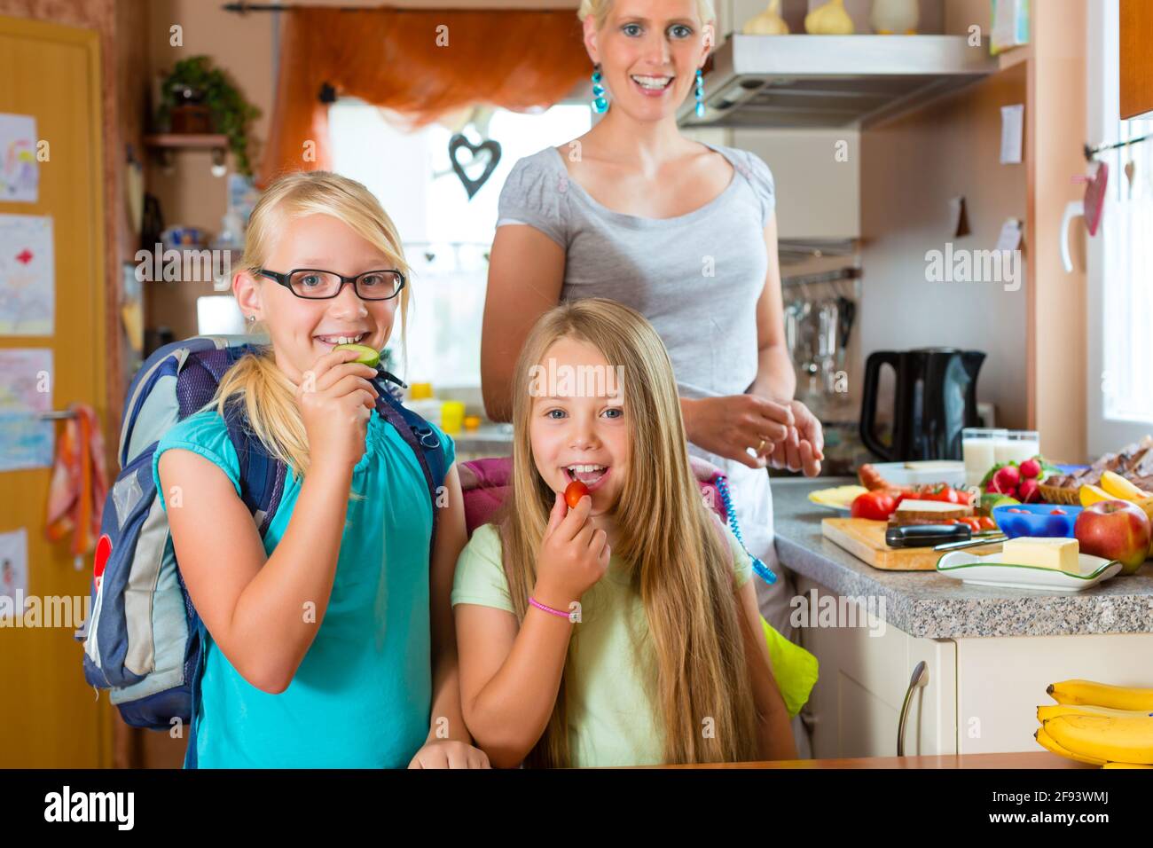 Familie - Mutter, die Zubereitung von Frühstück am Morgen und einen Snack für die Schule für ihre Kinder Stockfoto