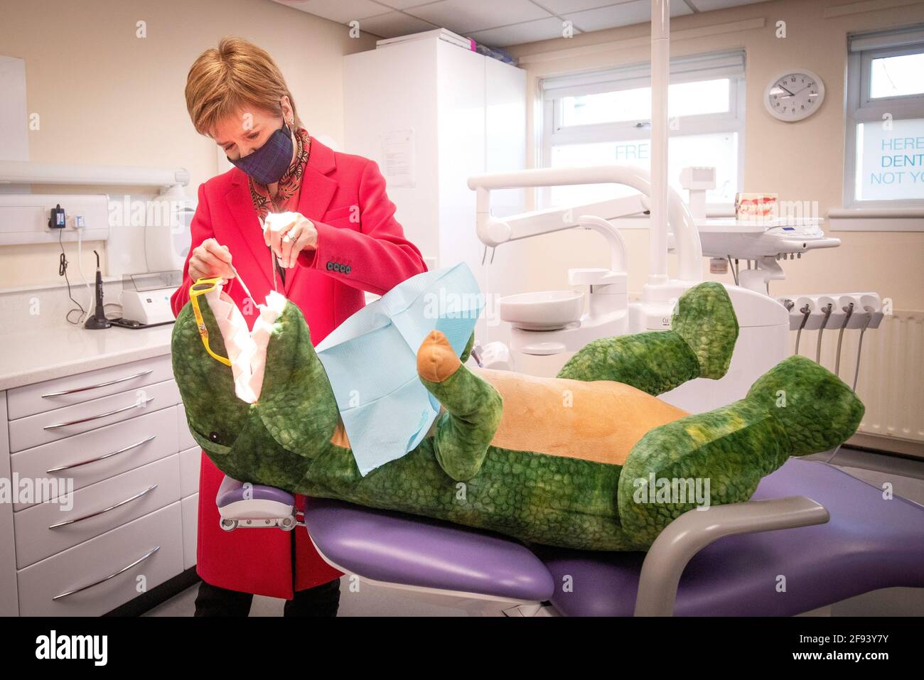 Schottlands erste Ministerin Nicola Sturgeon, Vorsitzende der Scottish National Party (SNP), prüft während eines Besuchs im Thornliebank Dental Care Center während des Wahlkampfs in Glasgow, Schottland, Großbritannien, am 16. April 2021 die Zähne von „Dentosaurus“. Jane Barlow/Pool via REUTERS Stockfoto