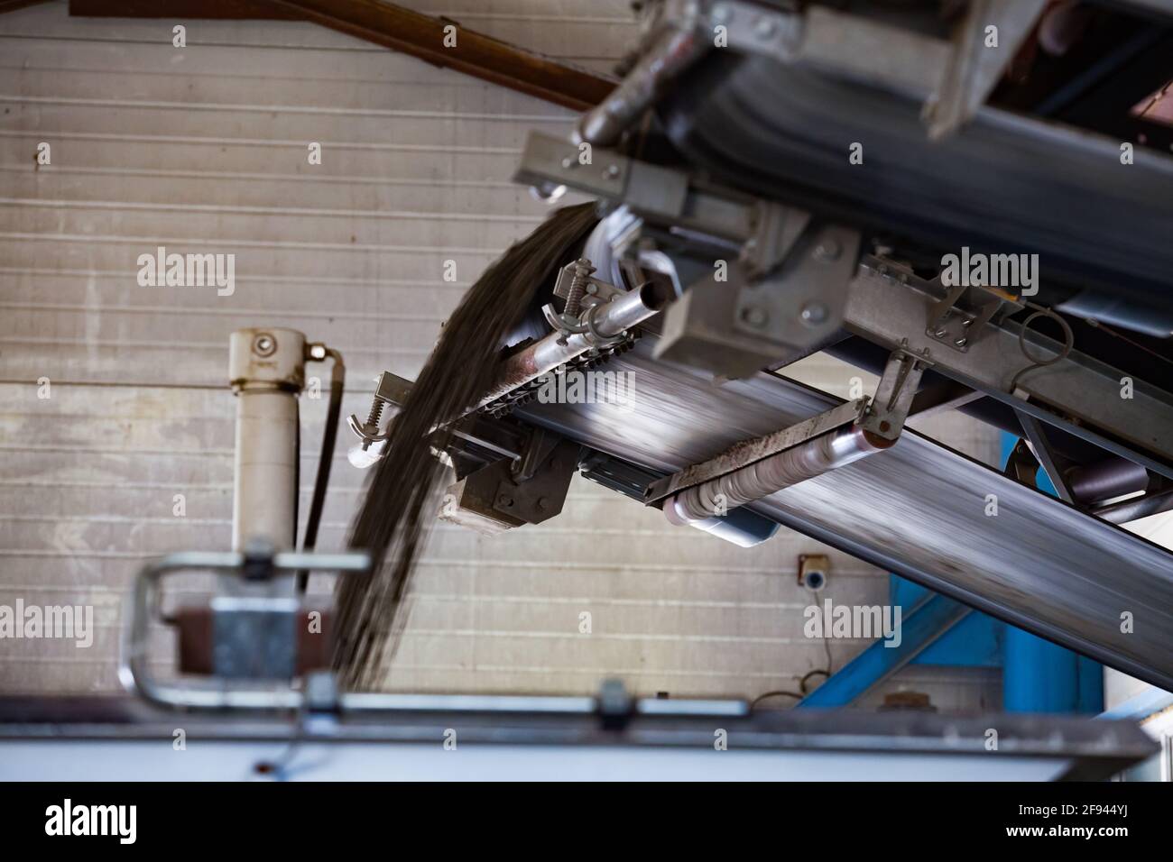 Nahaufnahme der Produktionsmaschine für Pflasterfliese, Gummiförderband mit trockenem Sandgemisch. Stockfoto