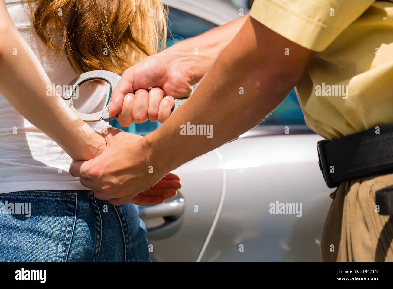 Polizisten verhaften eine Frau mit Handschellen Stockfoto