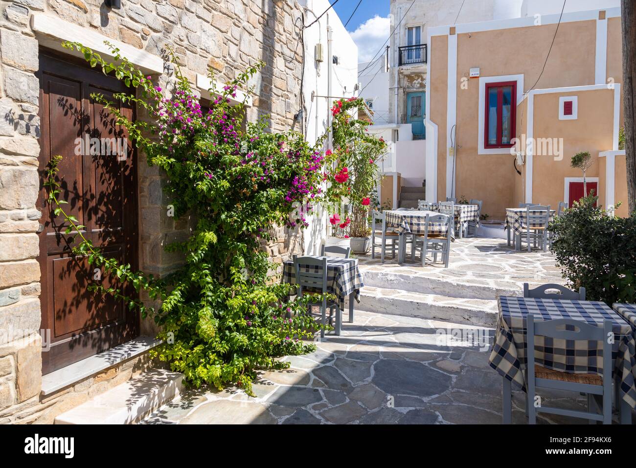 Naoussa, Insel Paros, Griechenland - 27. September 2020: Blick auf die enge Straße des Fischerdorfes mit lokalen Restaurants und Geschäften. Außentische für gu Stockfoto