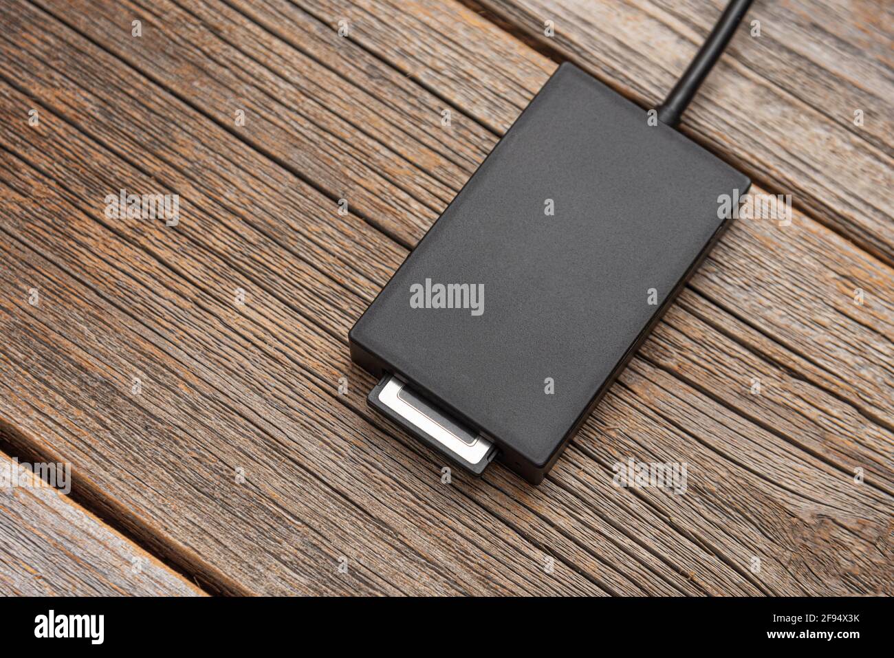Kartenleser für eine Hochgeschwindigkeits-Speicherkarte auf einem Holzhintergrund. Stockfoto