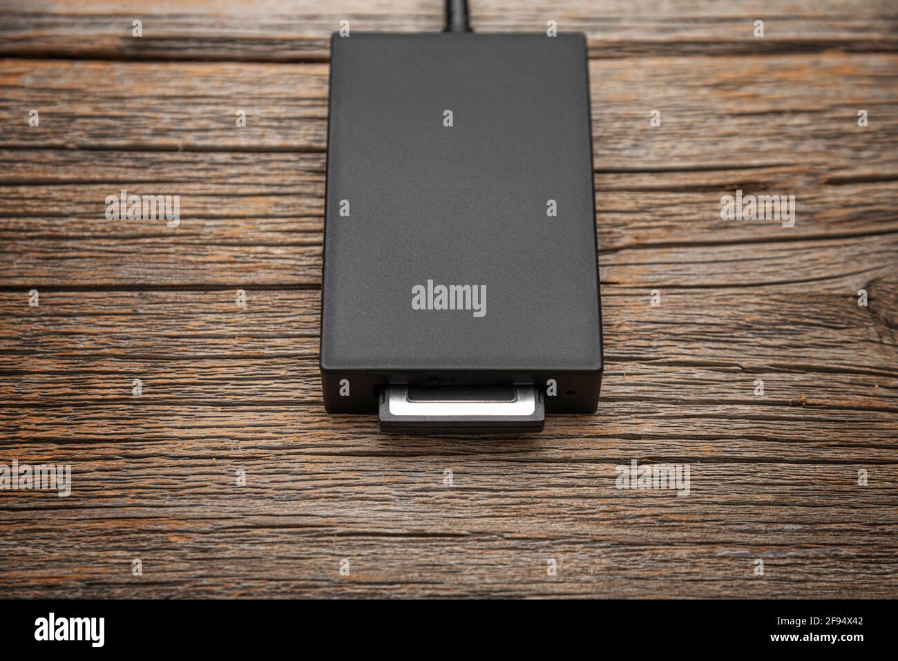 Kartenleser für eine Hochgeschwindigkeits-Speicherkarte auf einem Holzhintergrund. Stockfoto