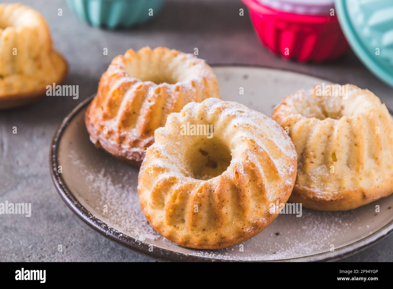 Hausgemachte Mini-Bündelkuchen mit Puderzucker auf grauem Hintergrund Stockfoto