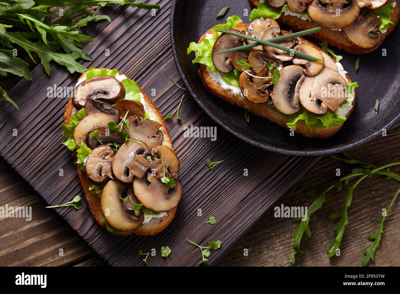 Sandwich mit Pilzen und Frischkäse auf einem rustikalen Holzhintergrund Nahaufnahme. Stockfoto