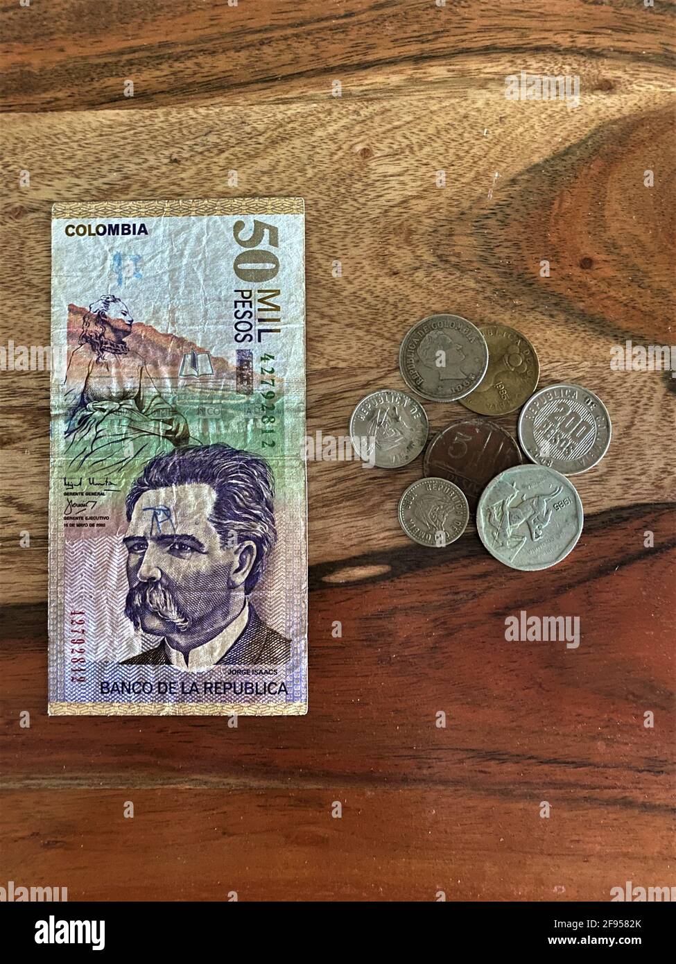 Kolumbianische Banknoten, Währung, Banknoten und Münzen auf Holzhintergrund. Banco de la Republica Stockfoto