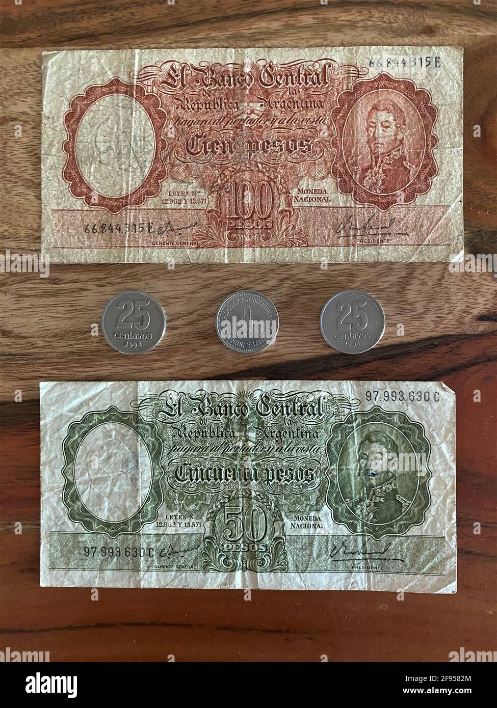 Währung aus Argentinien. Banknoten, Geldscheine und Münzen auf einem Holzhintergrund Stockfoto