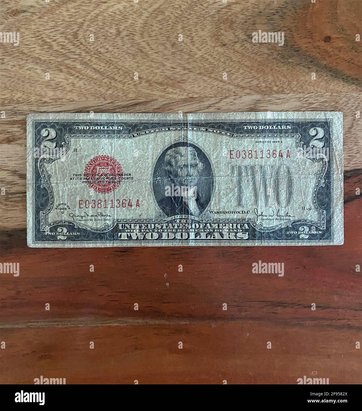Ein zwei-Dollar-Schein, isoliert auf einem Holzhintergrund. Stockfoto