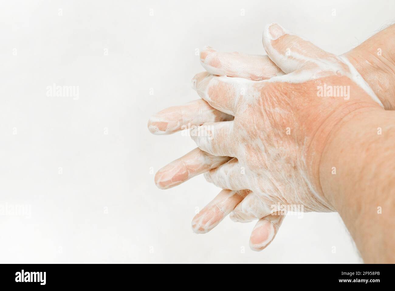 Älterer Mann wäscht die Hände mit Seife, Empfehlung für häufiges Händewaschen, Haushaltshygiene. Stockfoto