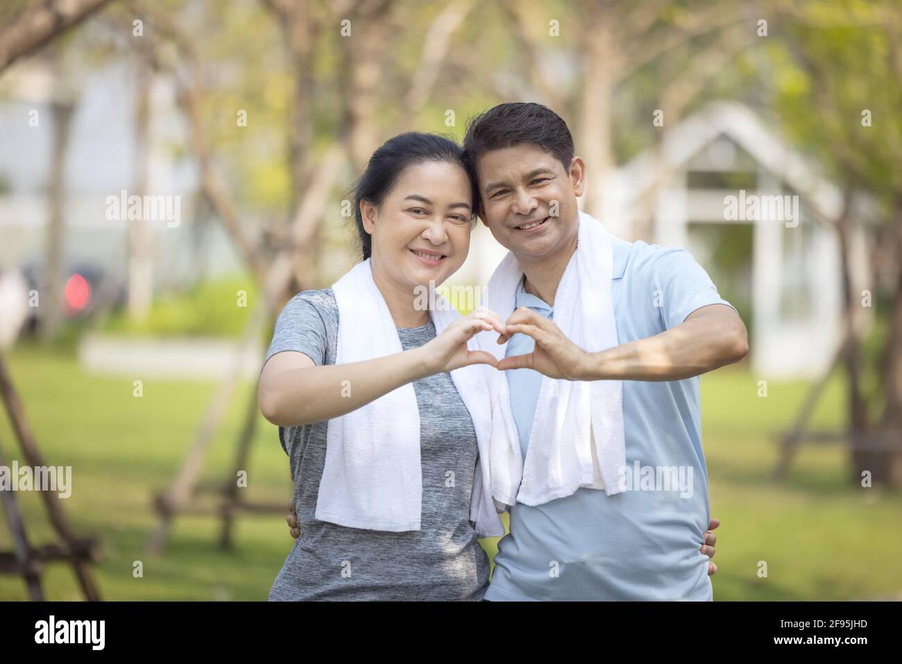 Aktives Seniorenpaar, das mit ihren Händen ein Herz schlägt Stockfoto