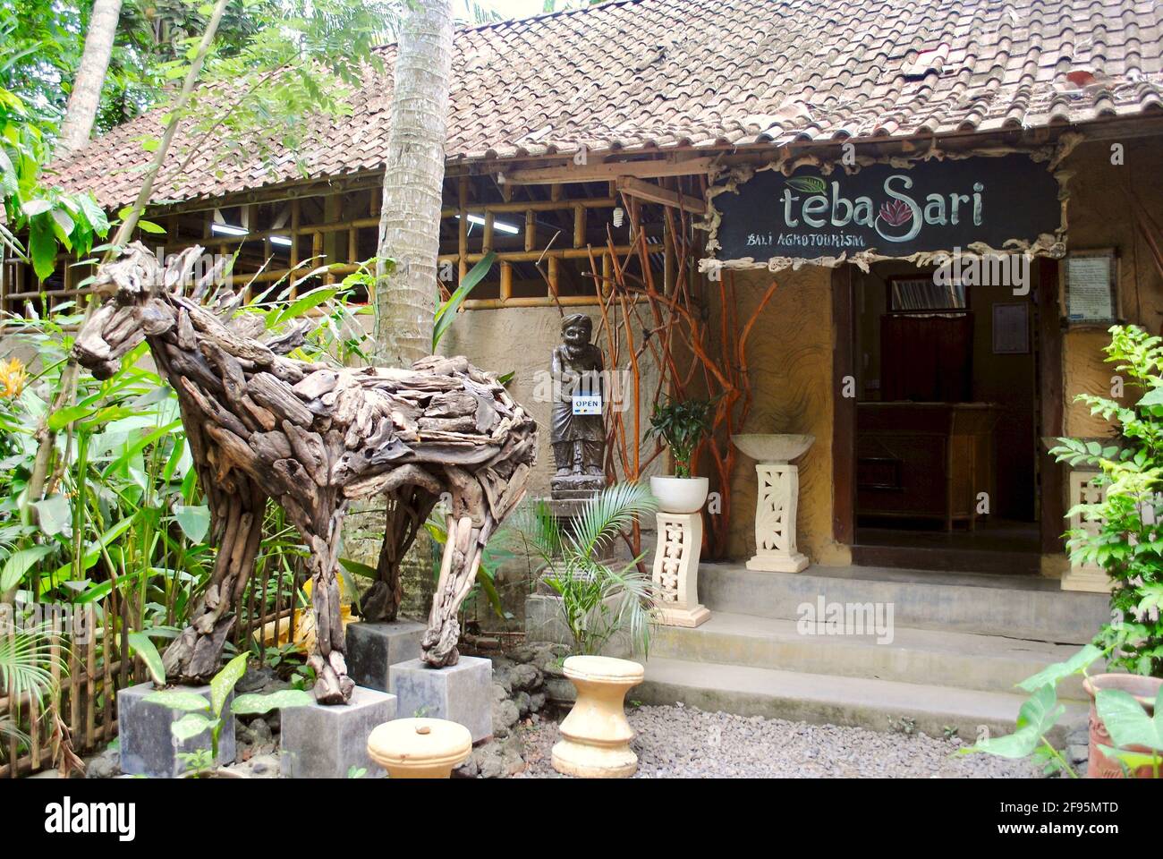 Bali, Indonesien: Eintritt zum Teba Sari Agrotourismus - ein kleiner Ort mit Luwak-Kaffee. Driftwood Pferdeskulptur und Ziegeldach. Stockfoto