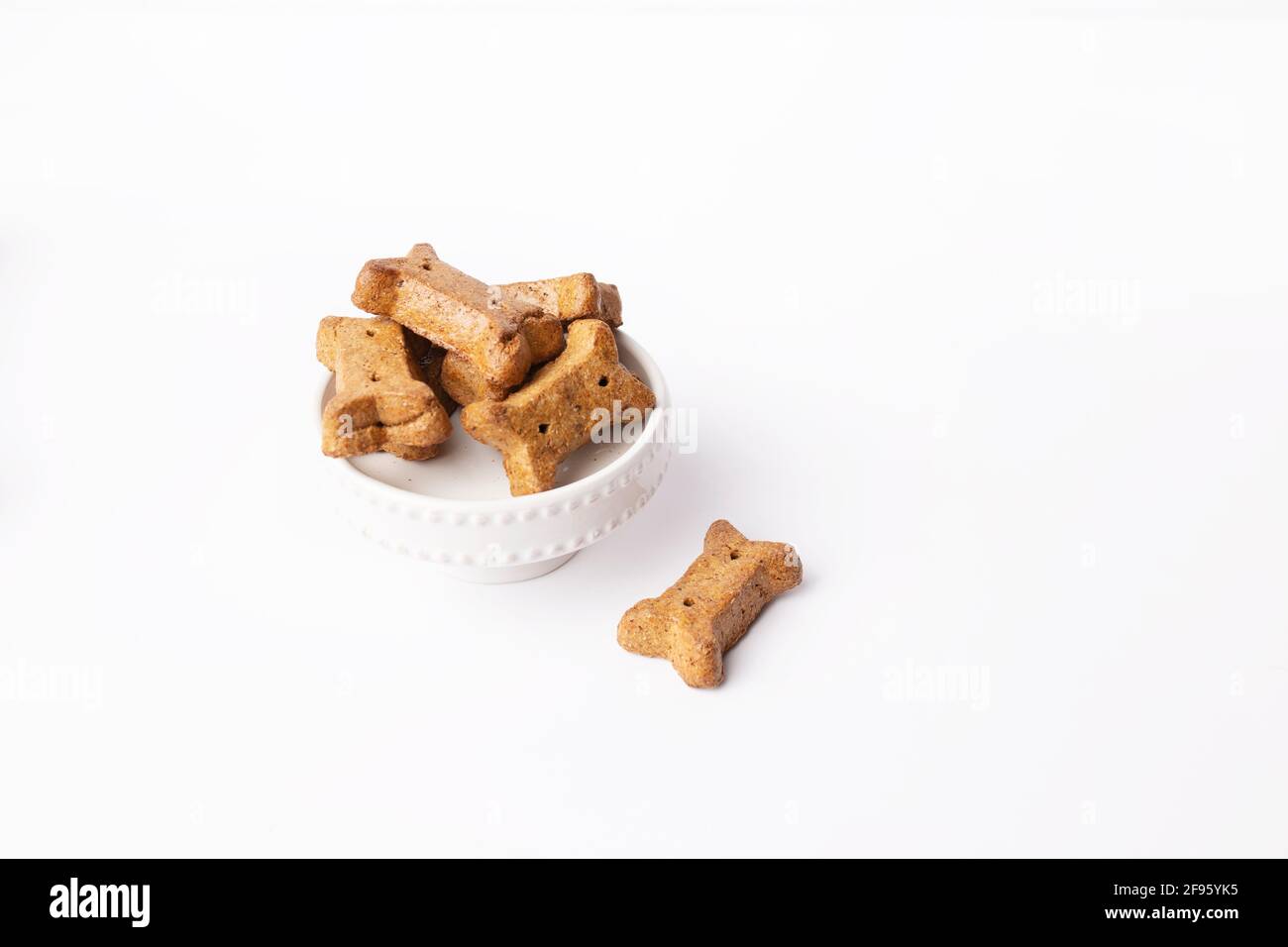 Haufen von braunen Knochen geformten Hund Leckereien auf Kuchen Sockel Auf weißem Hintergrund Stockfoto