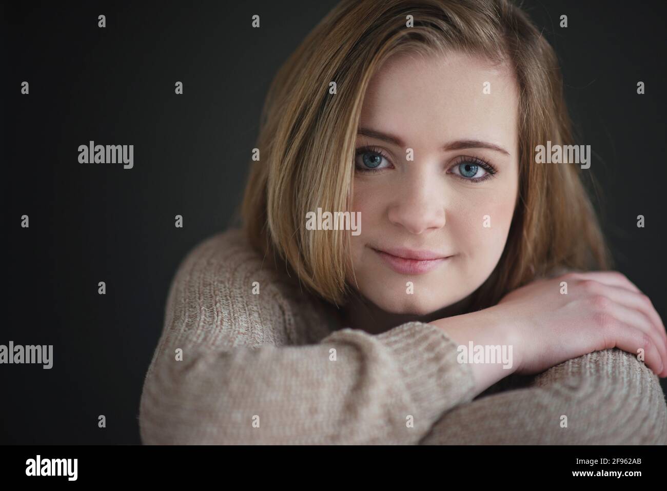 Schöne blonde teen Mädchen Spaß mehrere Posen auf grauem Hintergrund. Stockfoto