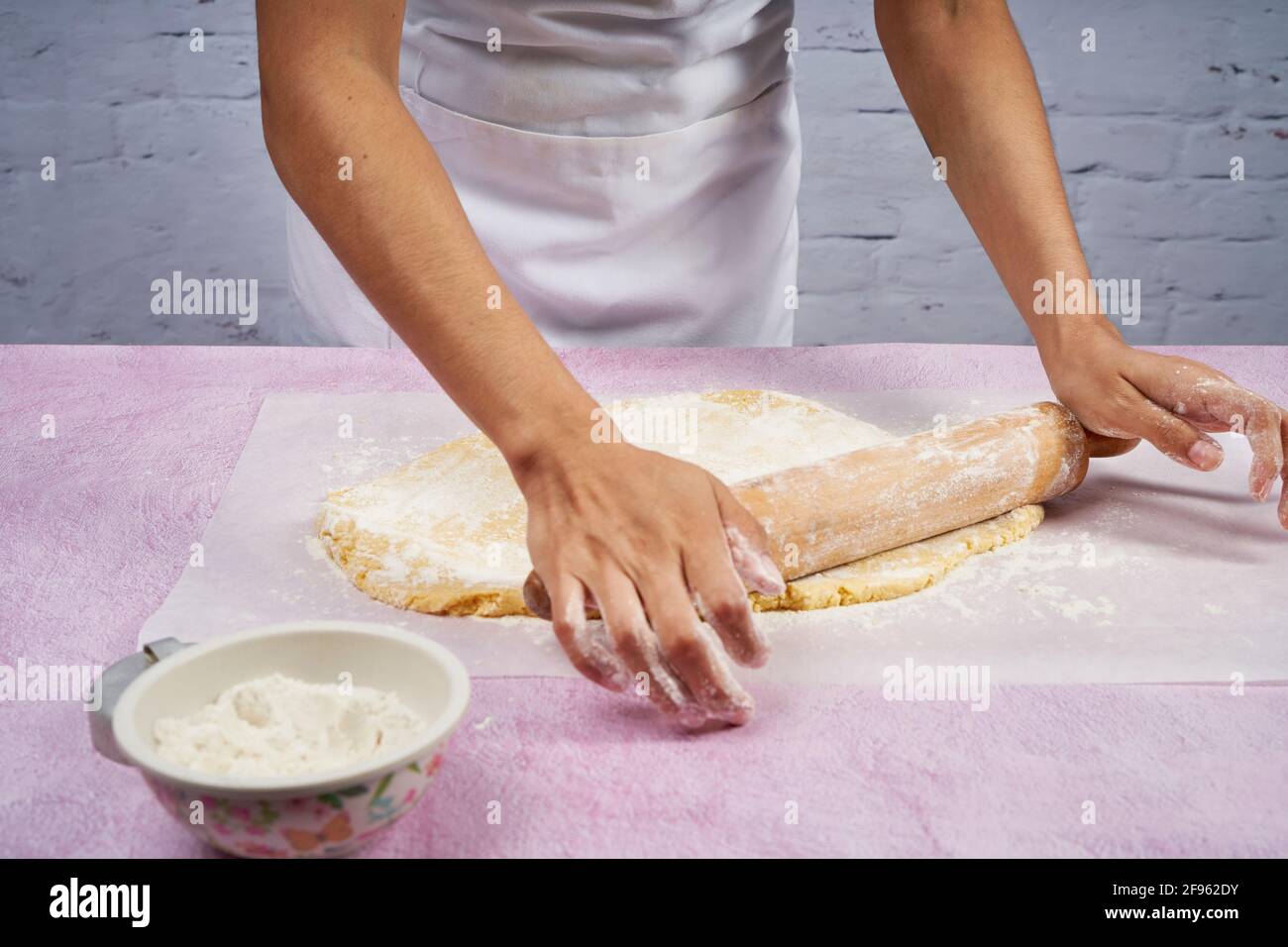 Den Teig mit dem Nudelholz abflachen, um die Alfajores vorzubereiten. Stockfoto