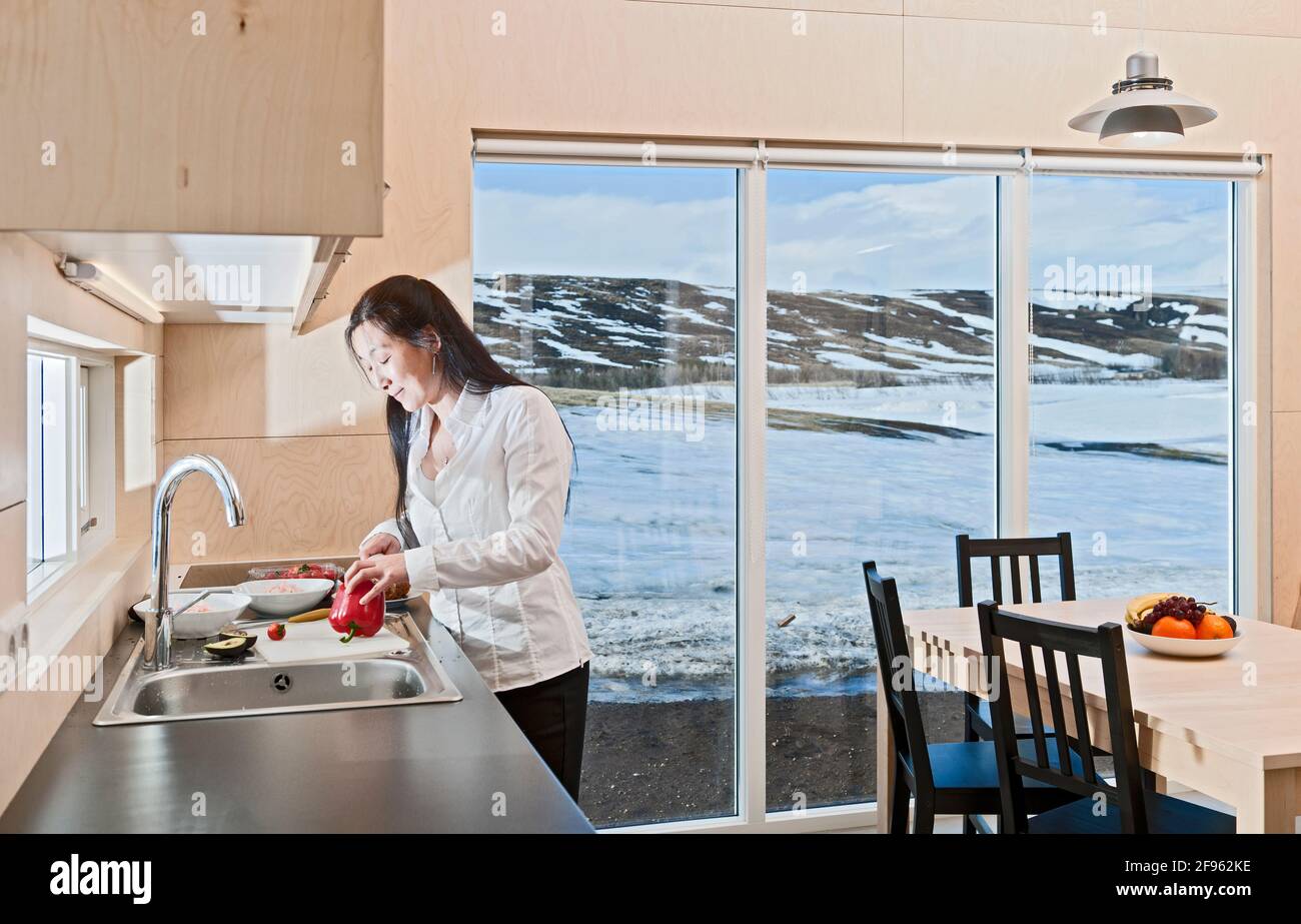 Frau, die Essen im isländischen Ferienhaus zubereitete Stockfoto