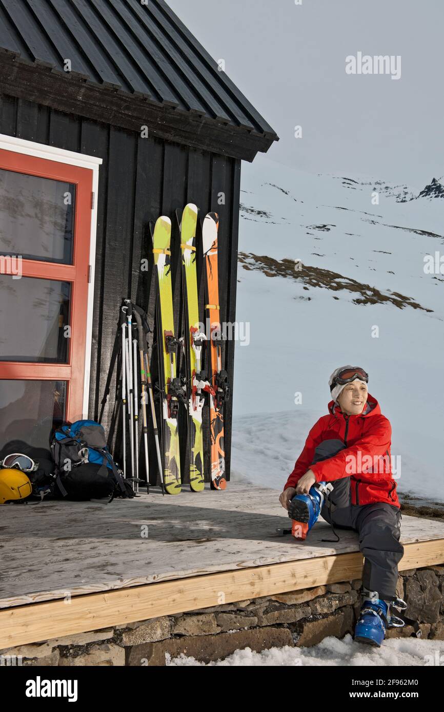 Frau, die sich für Skitouren in der Skihütte vorbereitet Island Stockfoto