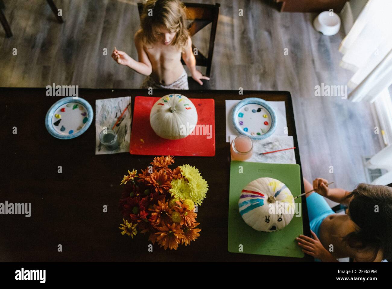 Schwestern malen zusammen Kürbisse für Halloween-Dekorationen Stockfoto