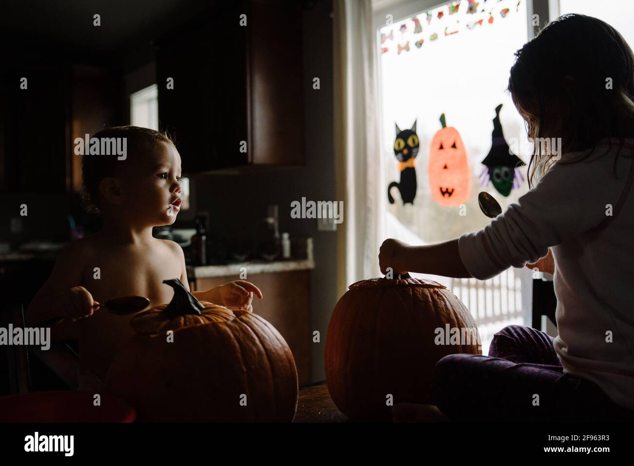 Zwei Kinder Kürbis schnitzen an halloween in ihrem Zuhause Stockfoto