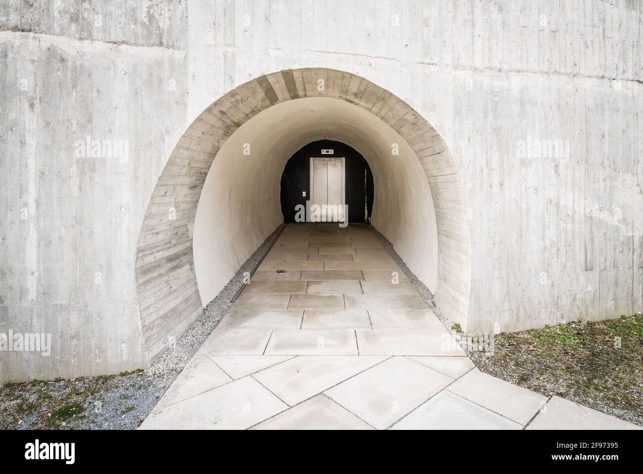 Detail eines in den Fels gehauenen Betons Zugang zu einem modernen Aufzug wie der eines Bunkers in den Berg mit dicken Mauern, Deutschland Stockfoto