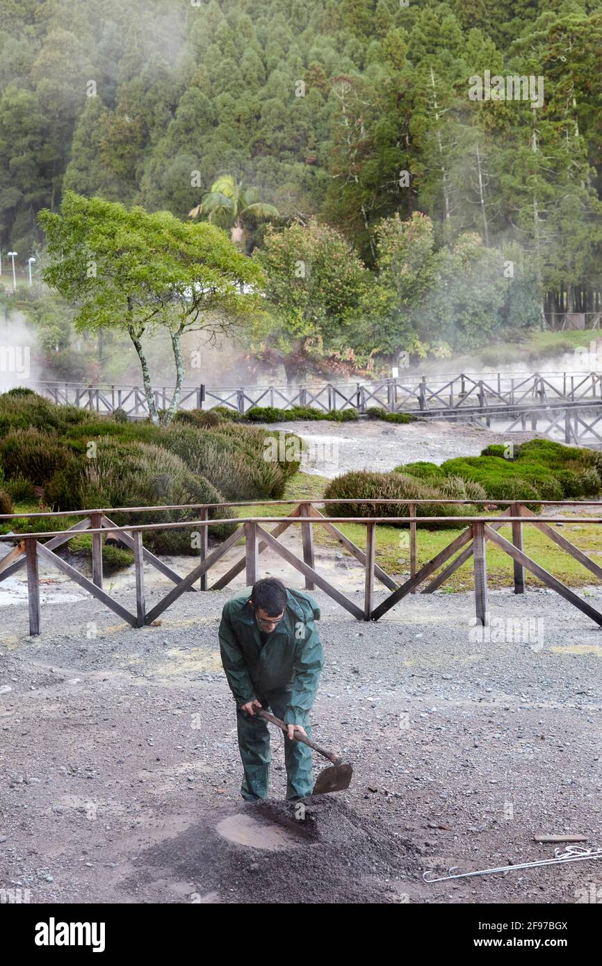 Ein Mann, der ein Loch in Fumarolis da Lagoa das Furnas für Cozido das Furnas auf der Insel Sao Miguel auf den Azoren, Portugal, grub Stockfoto