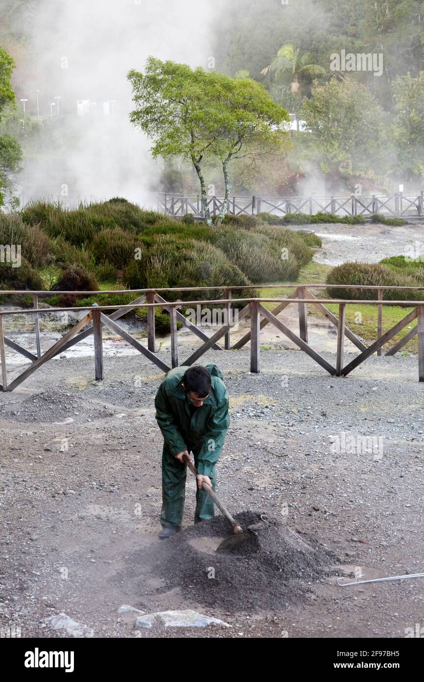 Ein Mann, der ein Loch in Fumarolis da Lagoa das Furnas für Cozido das Furnas auf der Insel Sao Miguel auf den Azoren, Portugal, grub Stockfoto