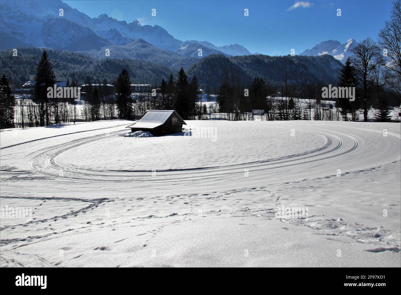 Langlaufloipe im Schloss Elmau Luxury Spa Retreat & Cultural Hideaway im Elmauer Tal zwischen Garmisch-Partenkirchen und Mittenwald. Rundkurs, Endlosschleife, Winter im Werdenfelser Land, Alpspitze, Wettersteingebirge, Europa, Deutschland, Oberbayern, Elmau, Klais, Krün bei Mittenwald, Traumwetter, Spuren im Schnee Stockfoto