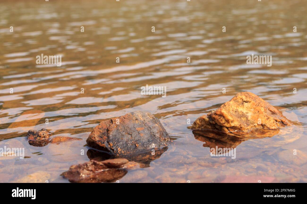 Nasse Felsen in klarem Wasser. Stockfoto