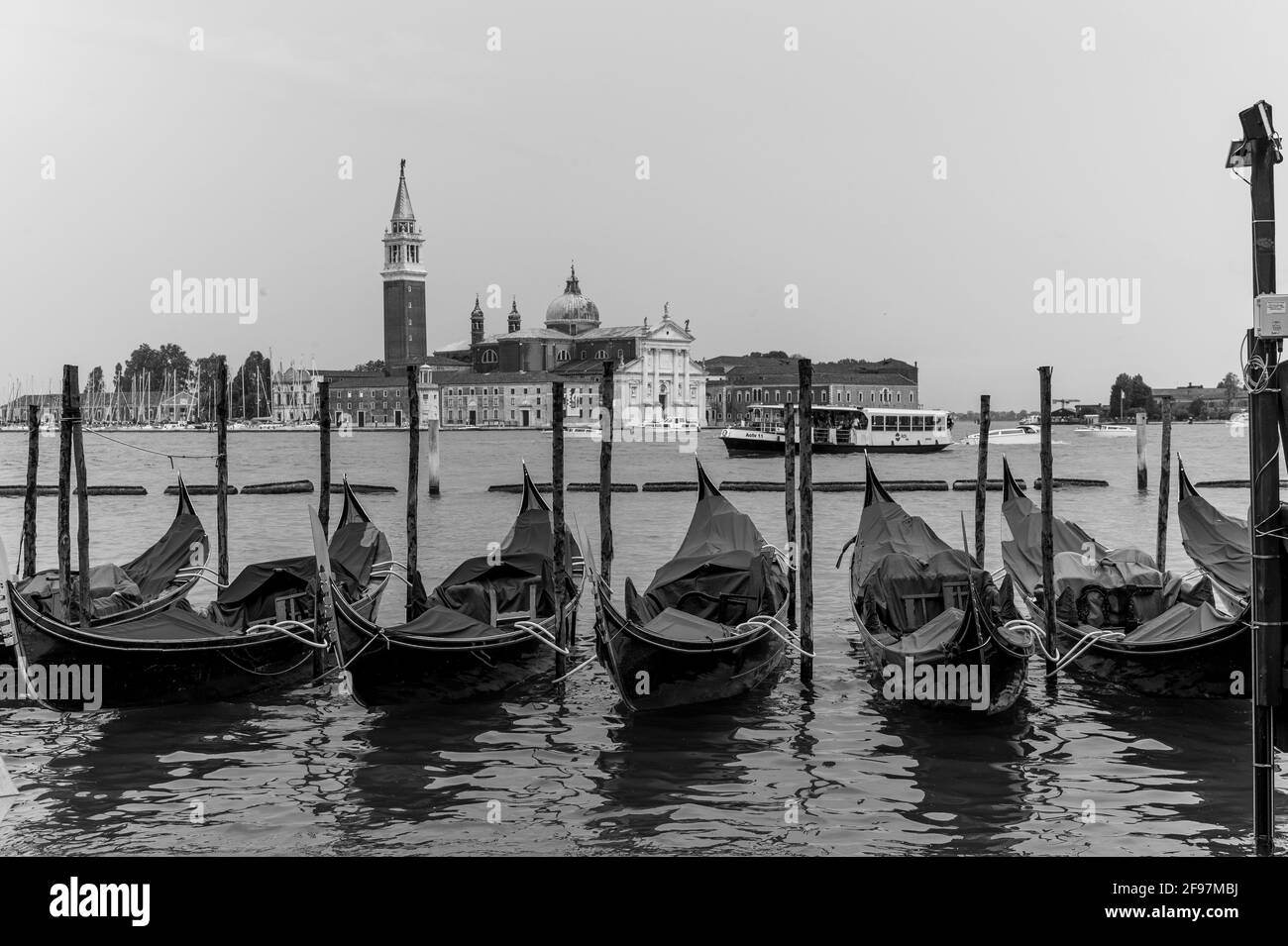 Monochrom-Aufnahme der traditionellen Gondeln am Canal Grande mit der Kirche San Giorgio Maggiore im Hintergrund, San Marco, Venedig, Italien. Aufgenommen mit Leica M Monochrom Stockfoto