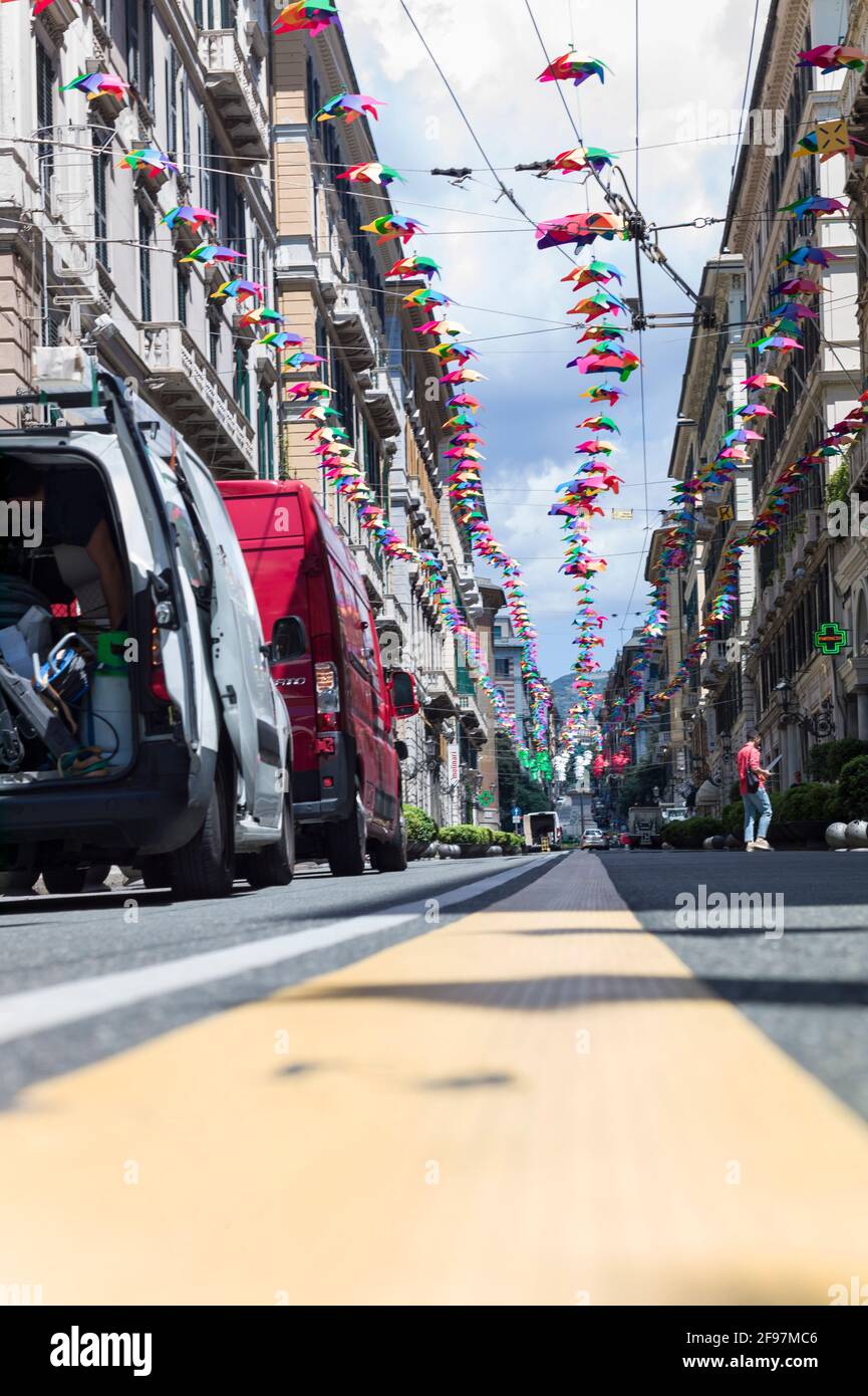 Niedrig positionierte Aufnahme von bunten, hellen Regenschirmen, die zwischen den Häusern entlang der Straße „XXV Aprile“ im Zentrum der Stadt Genua (Italien) hängen Stockfoto