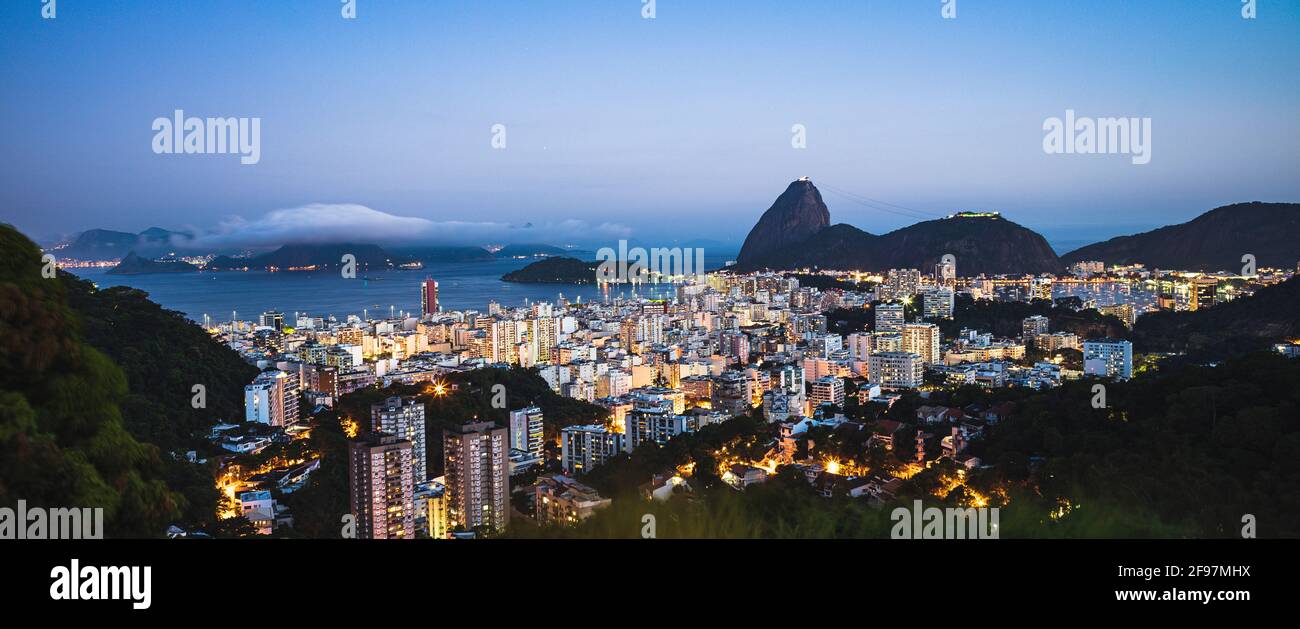 Langzeitbelichtung Panorama aufgenommen von der Skyline von Botafogo mit dem Zuckerhut hinten in Rio de Janeiro, Brasilien am Abend während des Sonnenuntergangs. Von Santa Teresa aus gesehen. Aufgenommen mit . Stockfoto