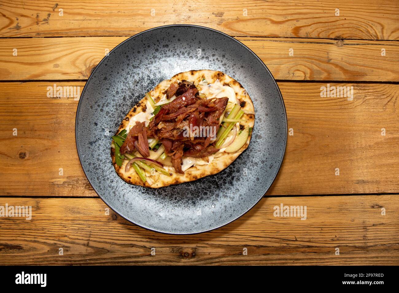 Ein köstlicher Teller mit zerfetztem Schinken mit Apfelschaber auf Eine hölzerne KüchentischEin köstlicher Teller mit geschreddertem Schinken Apple Slaw auf einem hölzernen Küchentisch Stockfoto