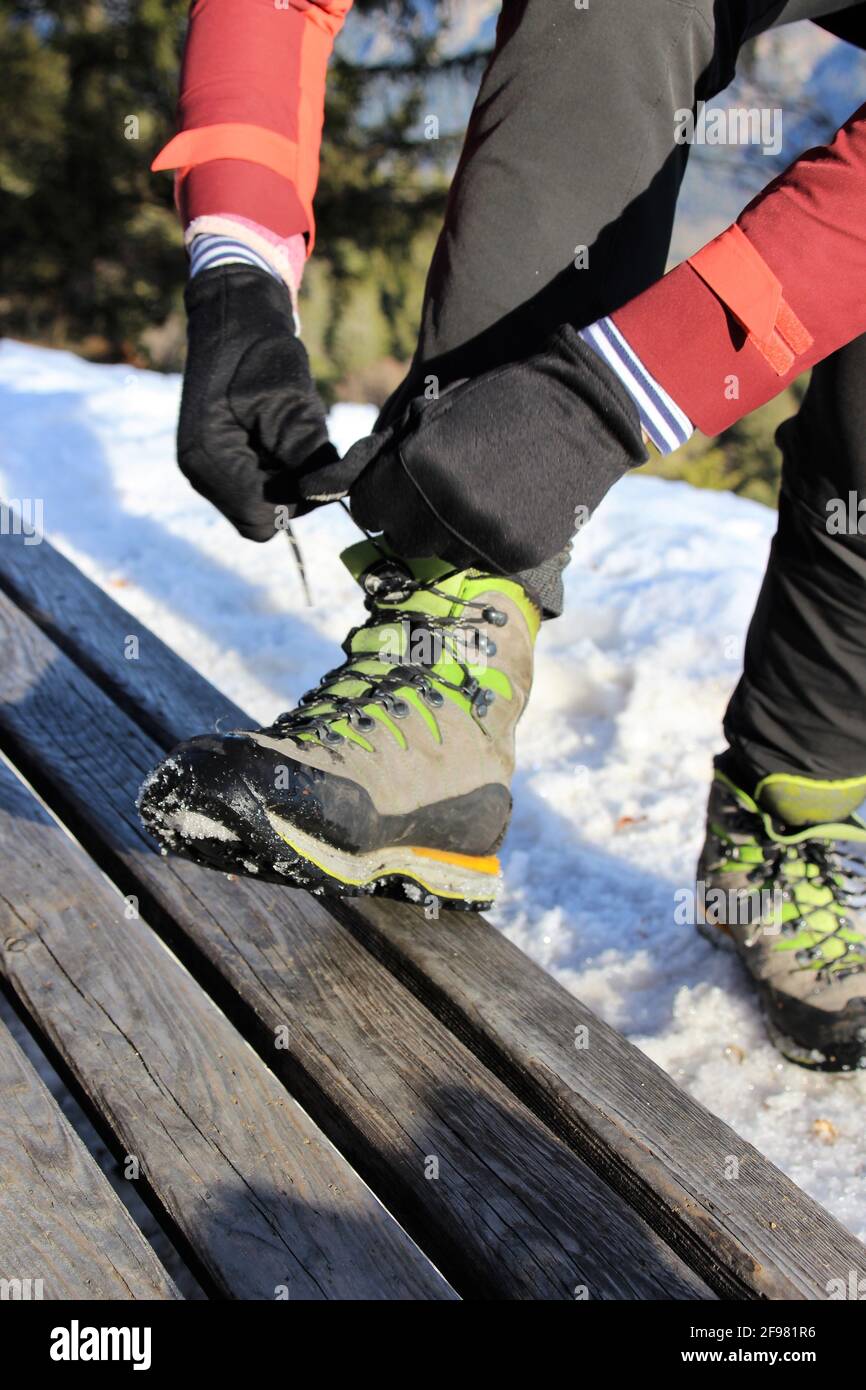 Frau bindet ihre Schnürsenkel während der Winterwanderung am Schafkopf bei Farchant, Europa, Deutschland, Bayern, Oberbayern, Garmisch-Partenkirchen, Loisachtal, Stockfoto