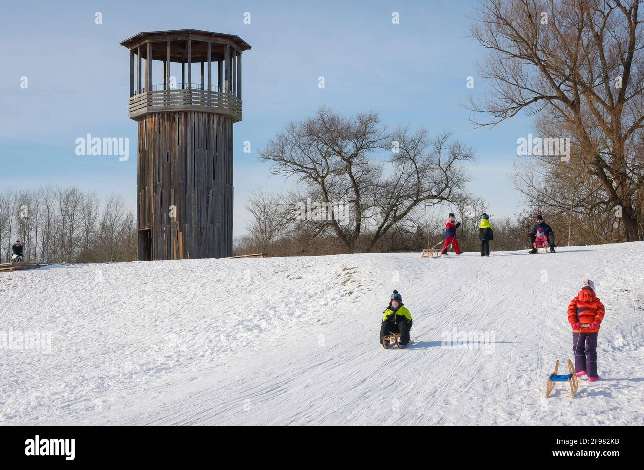 Recklinghausen, Nordrhein-Westfalen, Deutschland - sonnige Winterlandschaft im Ruhrgebiet, Emscherkunst im Schnee, Kawamata Tower auf der Emscher, GEHWEG UND TURM, 2010, von Tadashi Kawamata, Kinder fahren Schlitten. Stockfoto