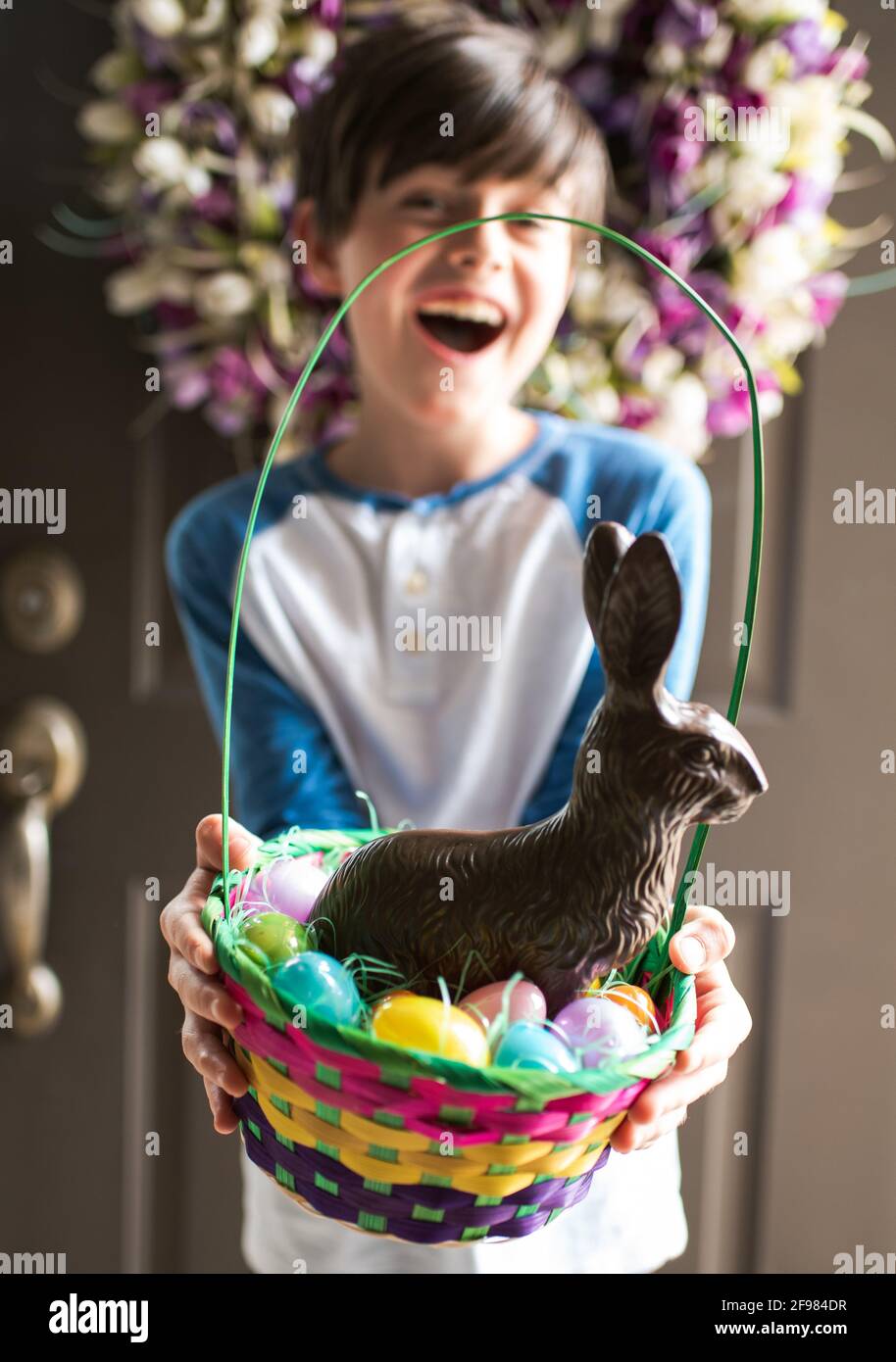 Junge glücklich Junge hält Ostern Korb voller Eier und Schokoladenhase Stockfoto