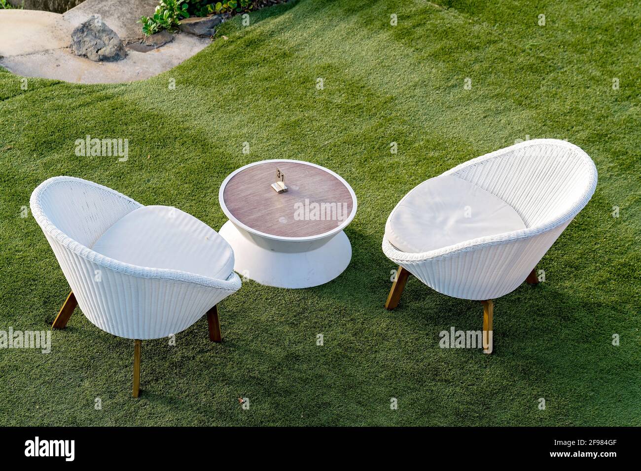 Zwei weiße Korbsessel und ein Tisch Kunstrasen wartet auf Hotelgäste  Stockfotografie - Alamy