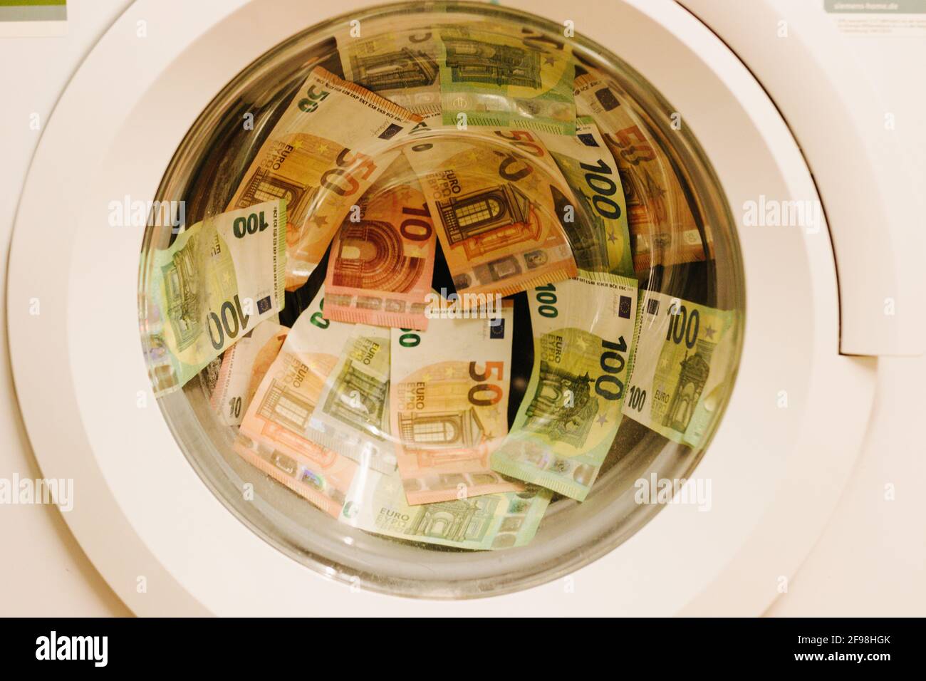 Geld in der Waschmaschine, Symbol Geldwäsche Stockfotografie - Alamy