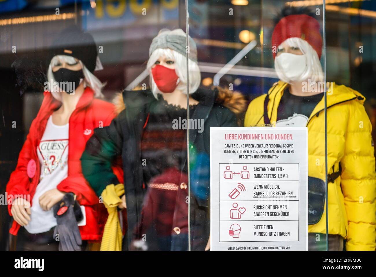 Krefeld, Nordrhein-Westfalen, Deutschland - Krefelder Innenstadt in Zeiten der Koronakrise während der zweiten Schließung sind die meisten Geschäfte geschlossen, Schaufenster eines Modehauses in der Hochstraße, der Haupteinkaufsstraße, Schaufenster mit Masken und Verhaltensregeln. Stockfoto