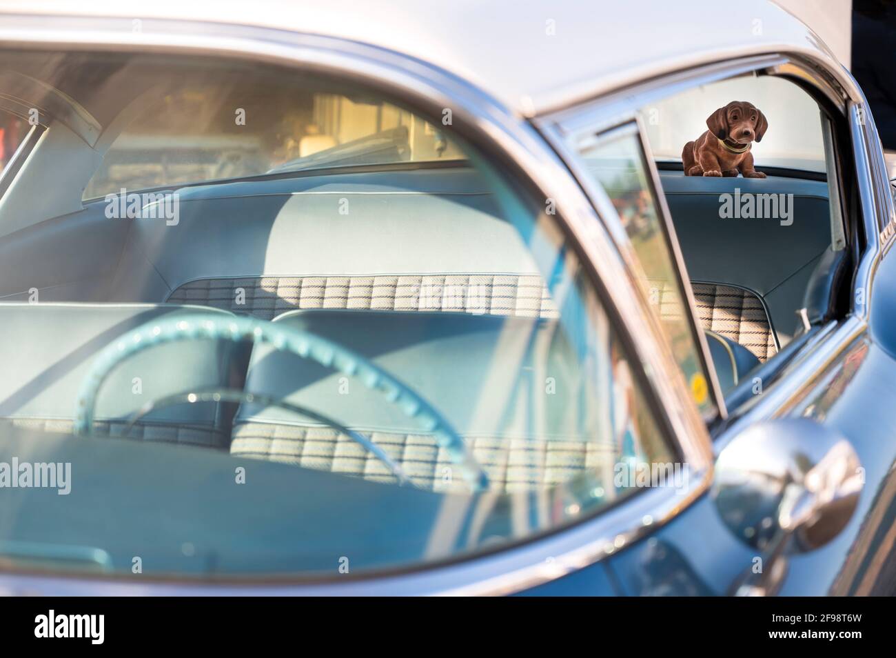 Nostalgischer Bobble-Hund auf dem Paketregal eines Jahrgangs Auto Stockfoto