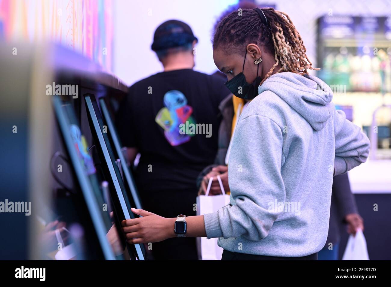 New York, USA. April 2021. Ein Kunde gibt einen Auftrag auf einem von zehn digitalen Bildschirmen innerhalb des neu eröffneten „Digital Only“ Cantina-Restaurants von Taco Bell entlang der 7th Avenue am Times Square, New York, NY, am 16. April 2021. Die Kunden haben Zugriff auf zehn Touchscreen-Menüs, über die sie ihre Lebensmittelbestellungen mit möglichst geringem Kontakt mit Menschen aufgeben und bezahlen können. Die Kunden lassen sich bei der Eingabe die Temperatur überprüfen und werden gebeten, sich für die Kontaktverfolgung in einem Buch zu registrieren. (Foto von Anthony Behar/Sipa USA) Quelle: SIPA USA/Alamy Live News Stockfoto