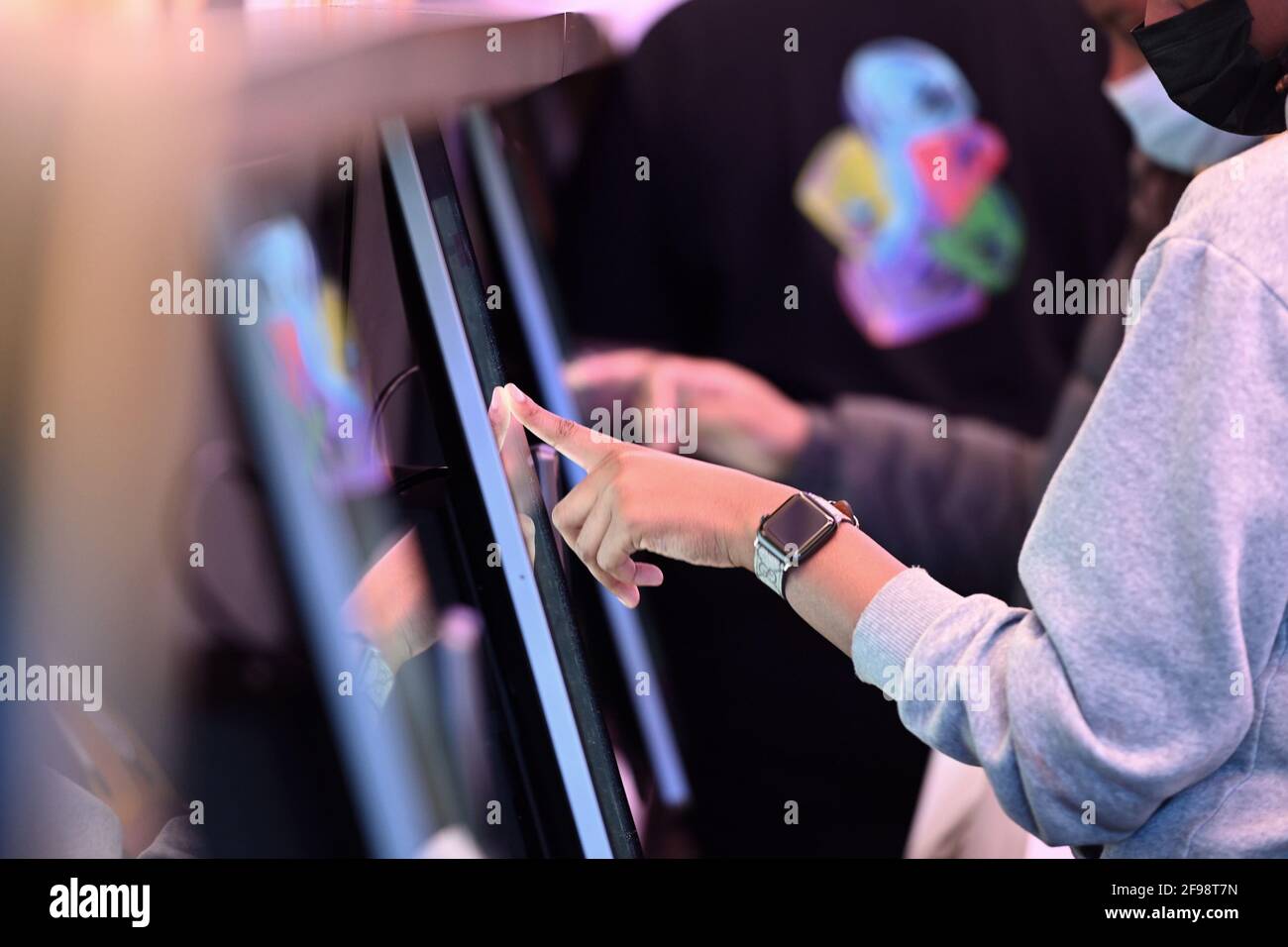 New York, USA. April 2021. Ein Kunde gibt einen Auftrag auf einem von zehn digitalen Bildschirmen innerhalb des neu eröffneten „Digital Only“ Cantina-Restaurants von Taco Bell entlang der 7th Avenue am Times Square, New York, NY, am 16. April 2021. Die Kunden haben Zugriff auf zehn Touchscreen-Menüs, über die sie ihre Lebensmittelbestellungen mit möglichst geringem Kontakt mit Menschen aufgeben und bezahlen können. Die Kunden lassen sich bei der Eingabe die Temperatur überprüfen und werden gebeten, sich für die Kontaktverfolgung in einem Buch zu registrieren. (Foto von Anthony Behar/Sipa USA) Quelle: SIPA USA/Alamy Live News Stockfoto