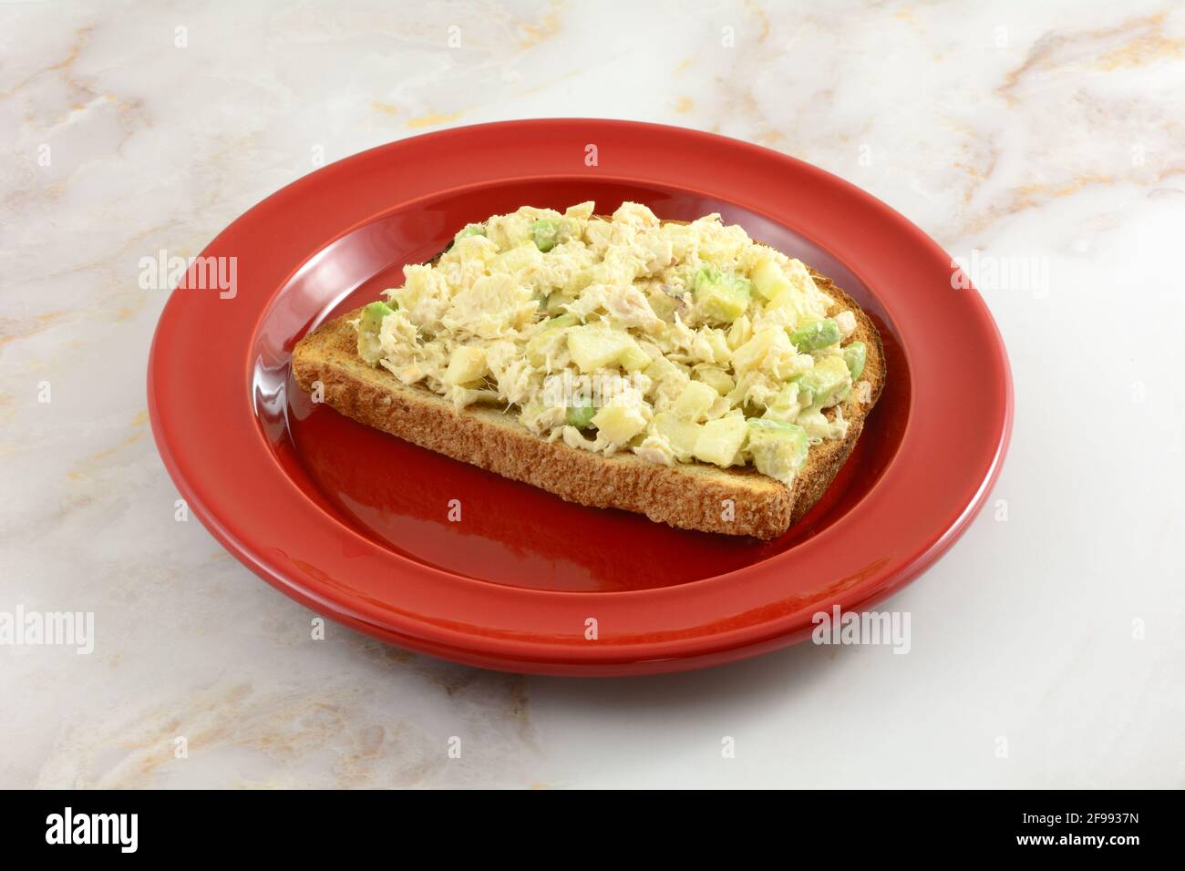 Offenes Thunfischsalat-Sandwich mit gehacktem Apfel und Avocado Auf Vollkornbrot Toast auf rotem Luncheon Teller Stockfoto