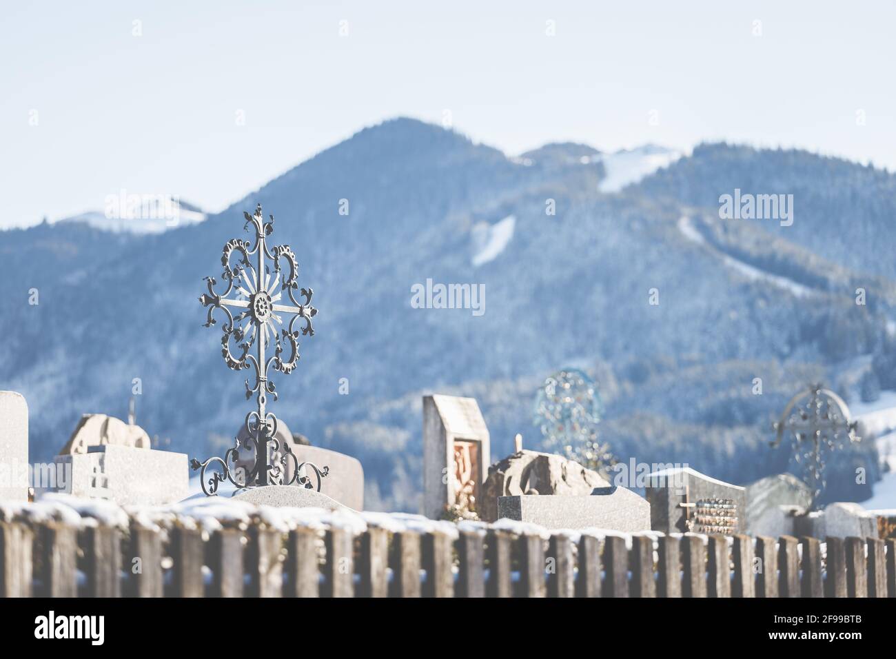 Ein schmiedeeisernes Metallkreuz auf einem Friedhof in den bayerischen Bergen. Stockfoto