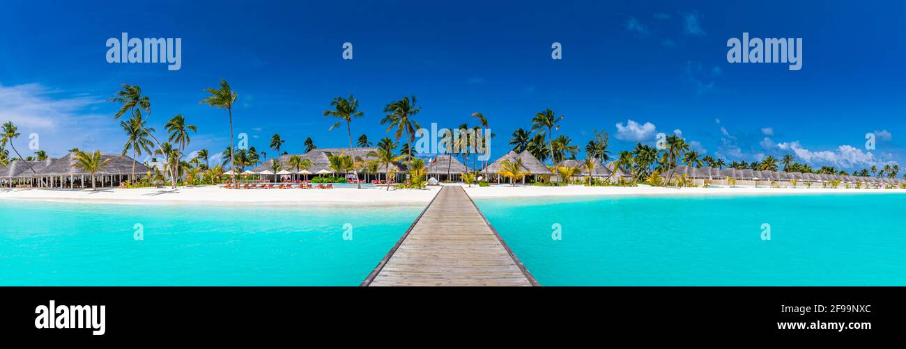 Panoramablick auf exotische Palmen und Lagune am tropischen Inselstrand. Luxus-Resort-Hotel, Villen, Bungalows mit Holzsteg. Tolle Reise Stockfoto