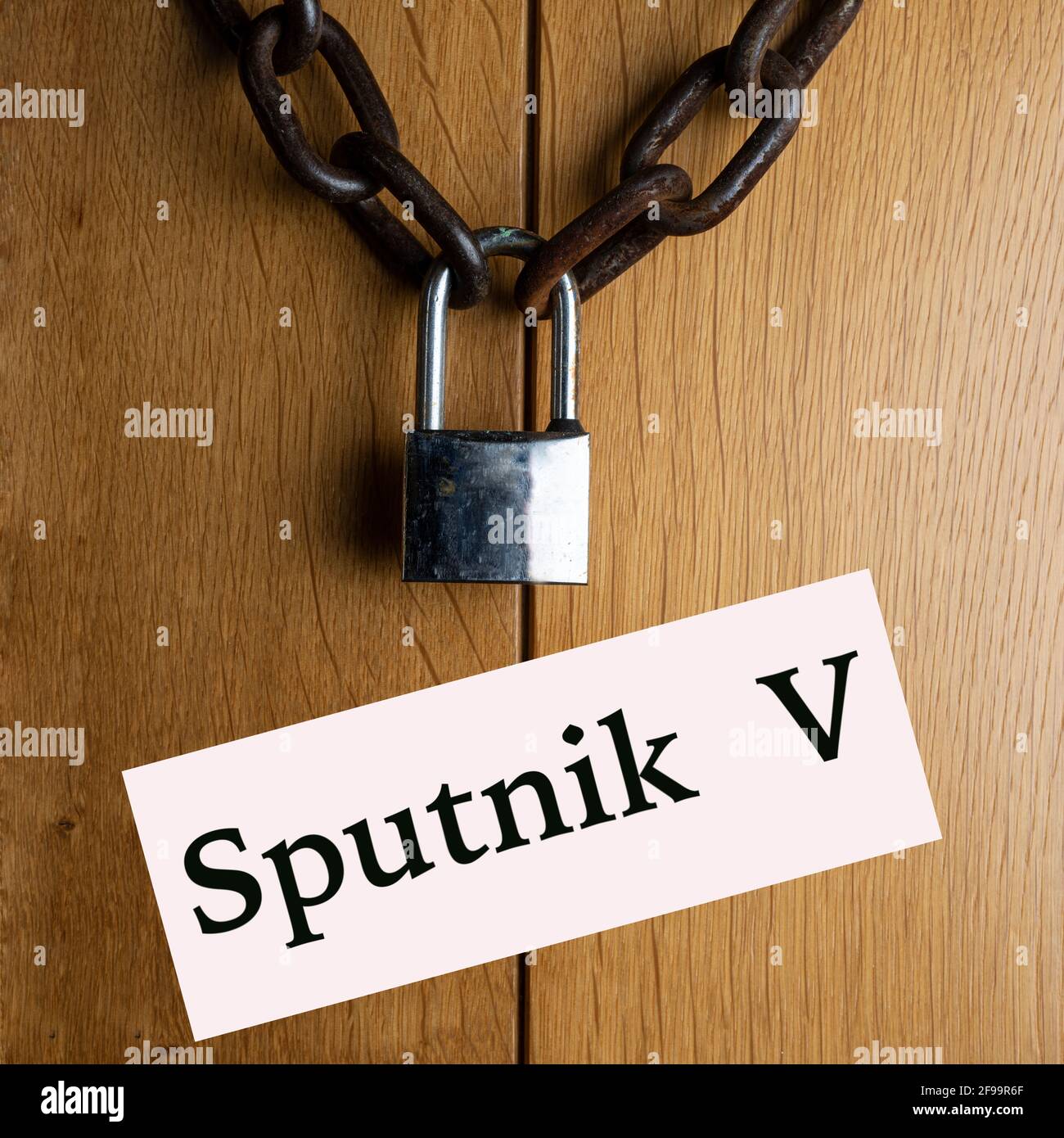 Die Holztür schloss sich mit der Kette und dem Vorhängeschloss an Sputnik V-Impfstoff Stockfoto